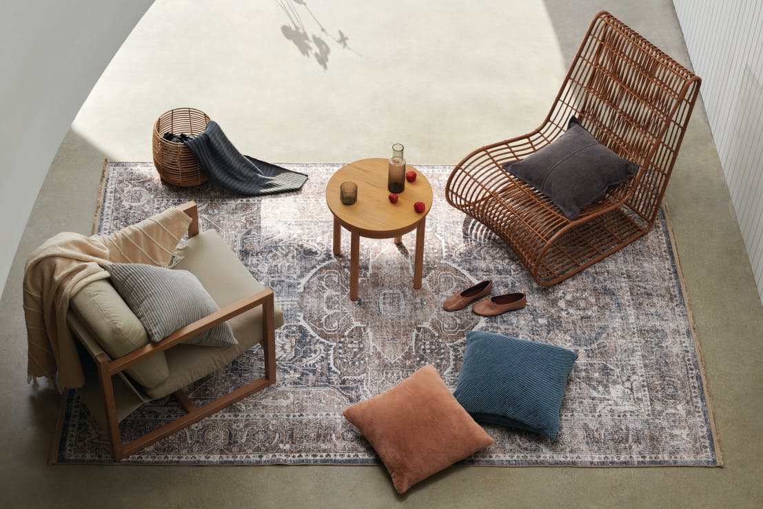 A plush seating area is adorned with velvet pillows and glass serveware.